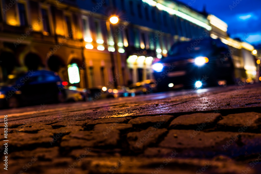 The bright lights of the evening city after rain, headlights from car