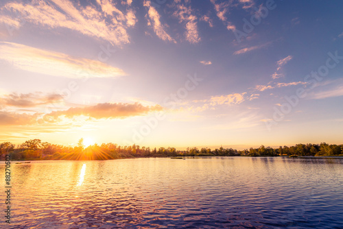 Sunset over the lake in the village. View from the coast