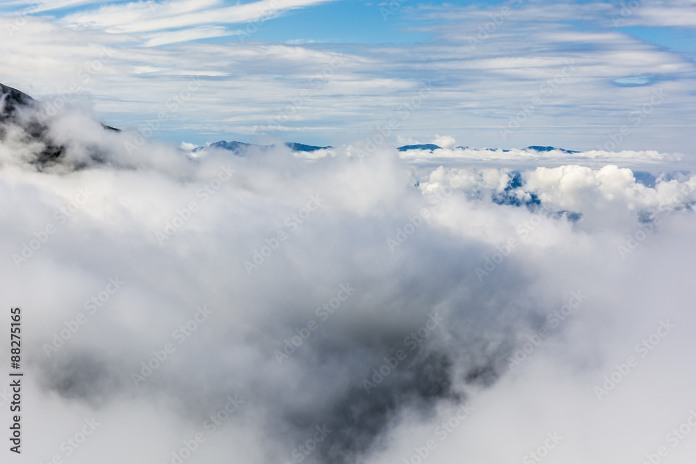 Above the clouds peaks on the horizon