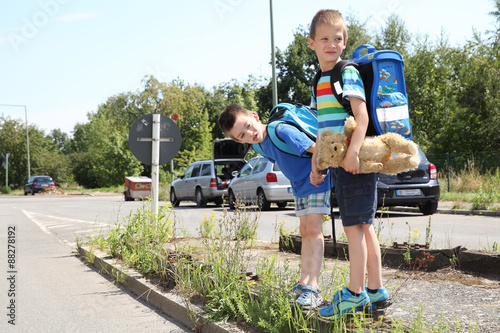 zwei Schulkinder beim überqueren der Straße