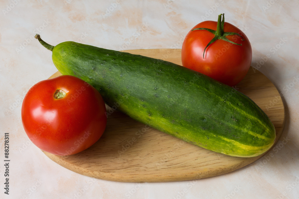 tomato and cucumber on a cutting board