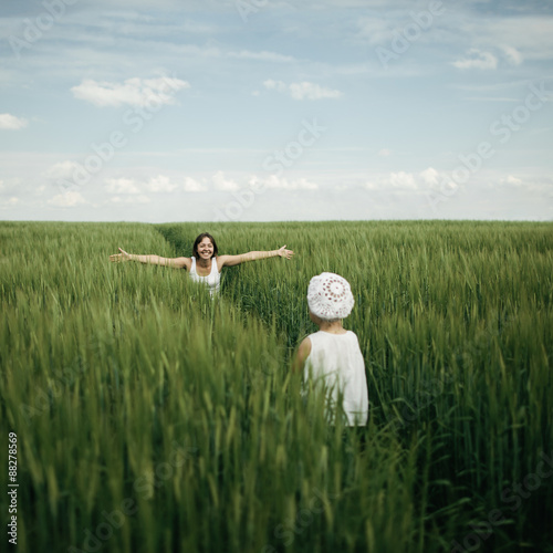 Mother meeting her daughter in spring green field