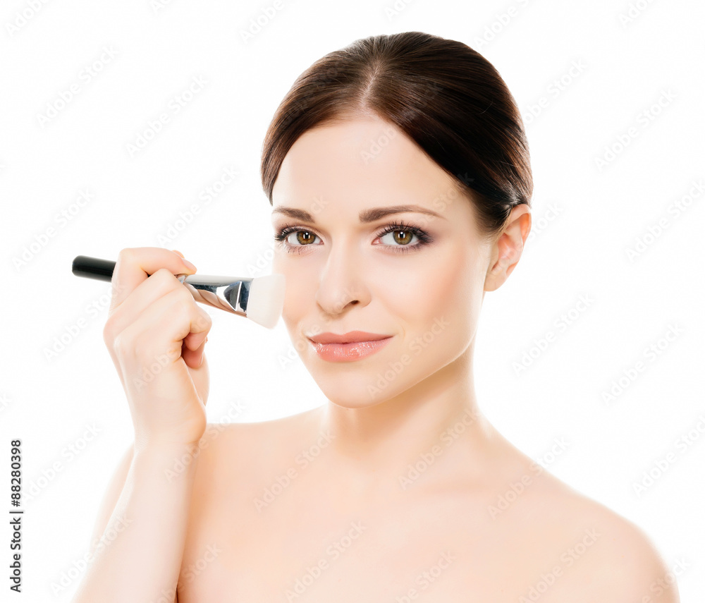 Beauty portrait of young, attractive, fresh, healthy and natural woman holding a makeup brush isolated on white