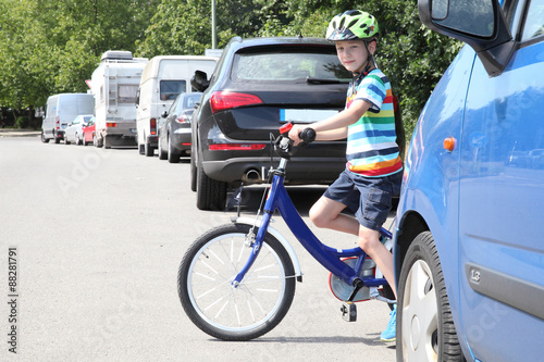 Junge mit Fahrrad am Straßenrand