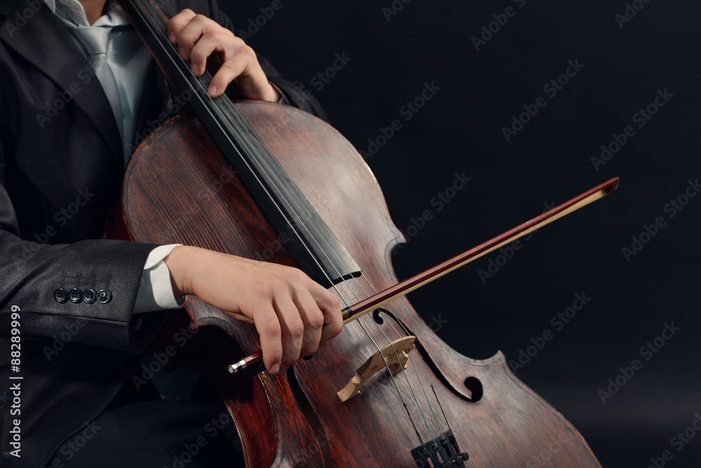 Man playing on cello on dark background Man playing on cello on dark background