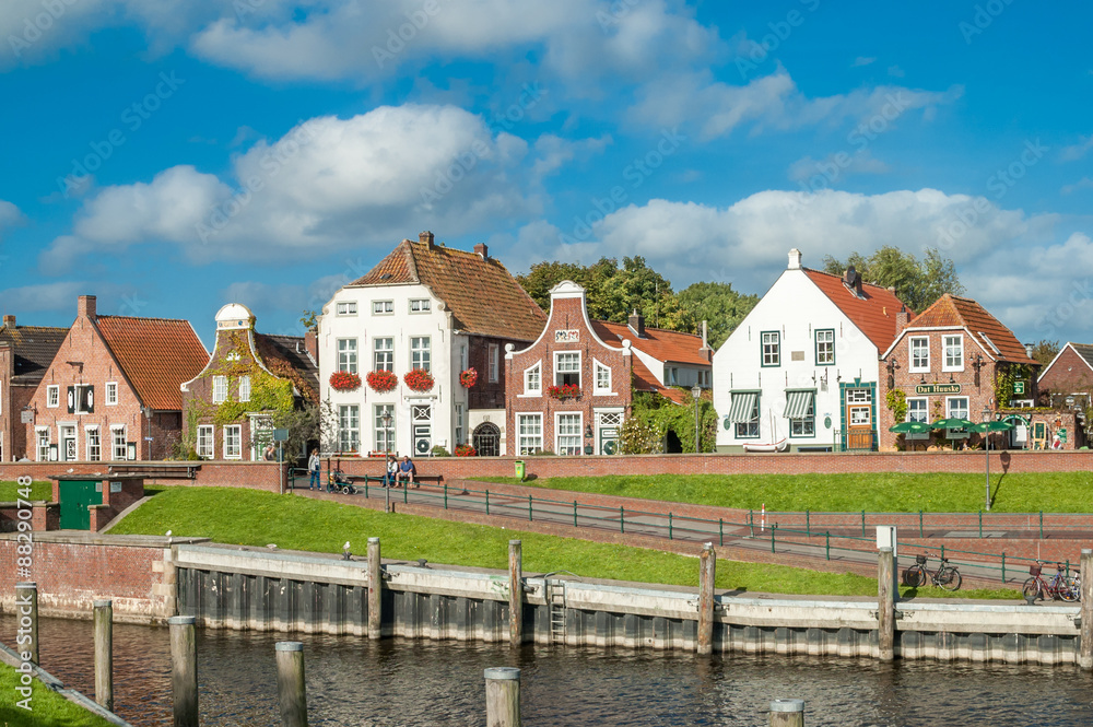 Facades of historic houses at Sielstrasse in the fishing harbour of Greetsiel, Lower Saxony, Germany