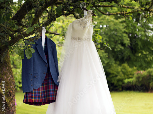 Kilt and wedding dress hanging on a tree