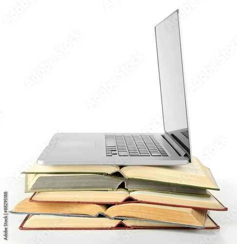 Stack of books with laptop isolated on white