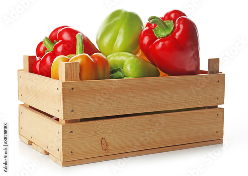 Colorful peppers in wooden crate isolated on white