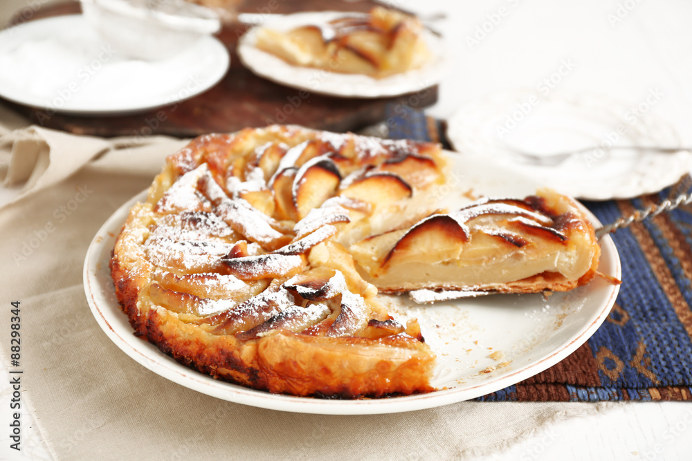 Homemade apple pie on plate, on white wooden table background background Homemade apple pie on plate, on white wooden table background background