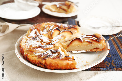 Homemade apple pie on plate, on white wooden table background background