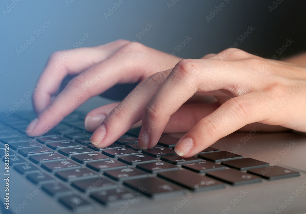Fototapeta premium Female hands typing on laptop keyboard, closeup