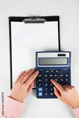 Hands working in the office with documents and calculator on white table