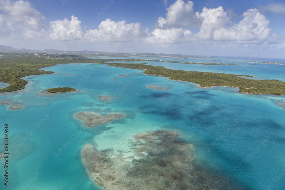 Aerial view of sections of reef scattered along the rugged coastline and rich tropical vegetation of Antigua, Leeward Islands Aerial view of sections of reef scattered along the rugged coastline and rich tropical vegetation of Antigua, Leeward Islands