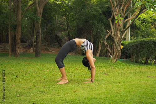 Young woman doing yoga exercises in the garden park