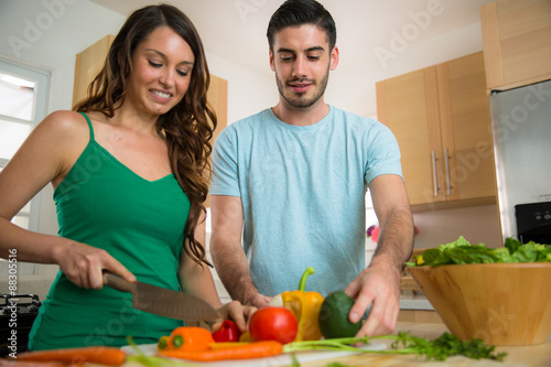 man and female dating single cooking from home salad veggies fajitas organic ingredients