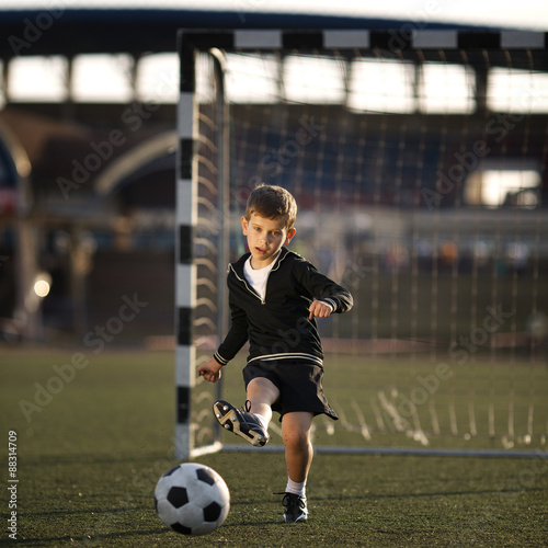 boy plays football on stadium