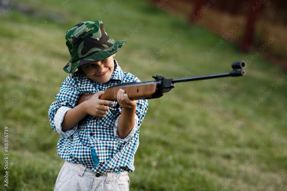 Fototapeta premium little boy with airgun outdoors