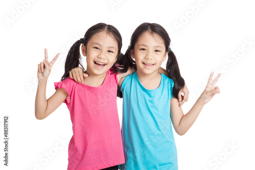 Happy Asian twins girls  smile show victory sign