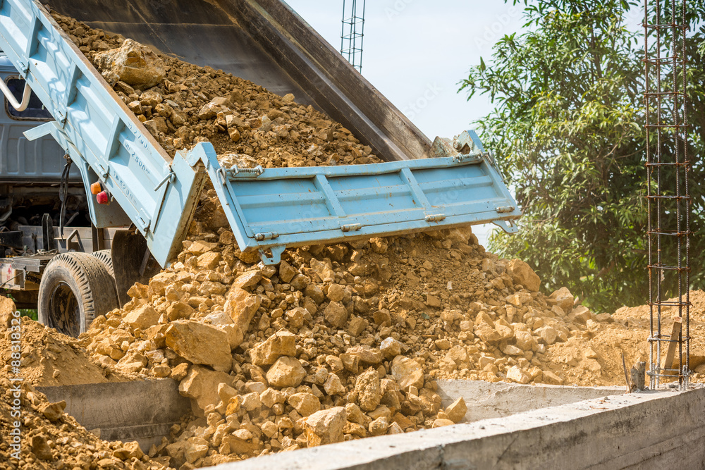 Obraz premium Dump truck unloading soil at construction site