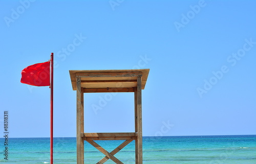 The red falg on the sea and the house of the lifeguard photo