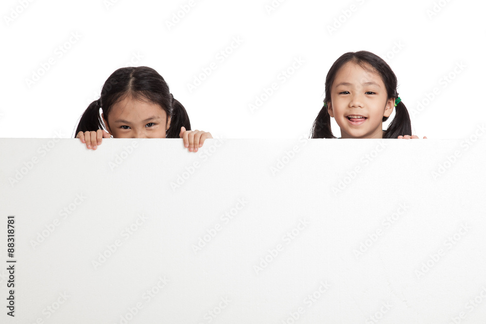 Happy Asian twins girls behind white blank banner Happy Asian twins girls behind white blank banner