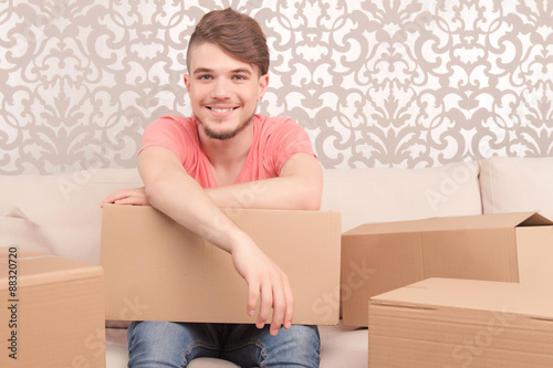 Pleased young husband holding box photo