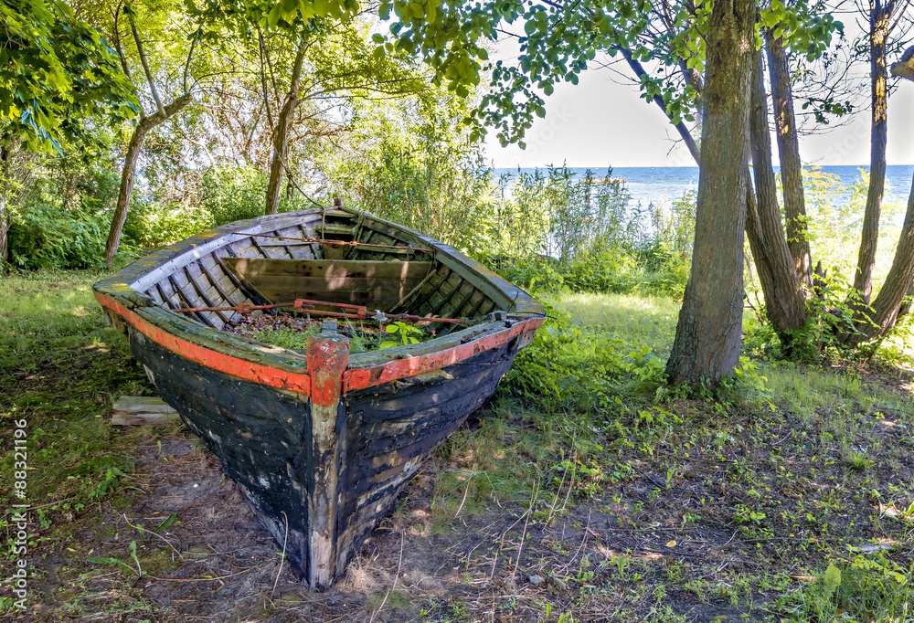 Broken old fishing boat anchored at a remote beach of the Baltic Sea, Latvia Broken old fishing boat anchored at a remote beach of the Baltic Sea, Latvia