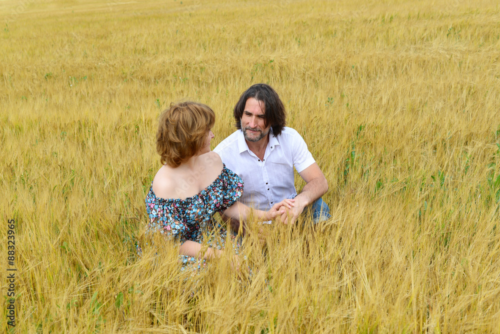 Loving middle-aged couple standing in field in summer Loving middle-aged couple standing in field in summer