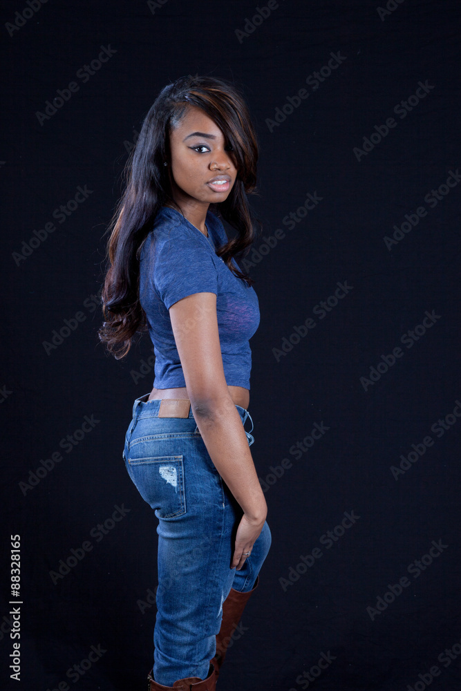 Thoughtful black woman in blue jeans Thoughtful black woman in blue jeans