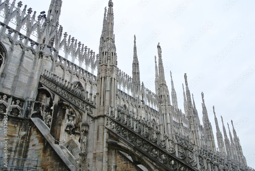 Architectural details from the roof of Milan Cathedral (Duomo di Milano) built in Gothic style, in white marble.