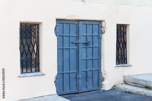 Steel old blue door with windows on the lattice on the backgroun