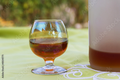 Copa y botella de cristal con licor alcoholico tostado photo