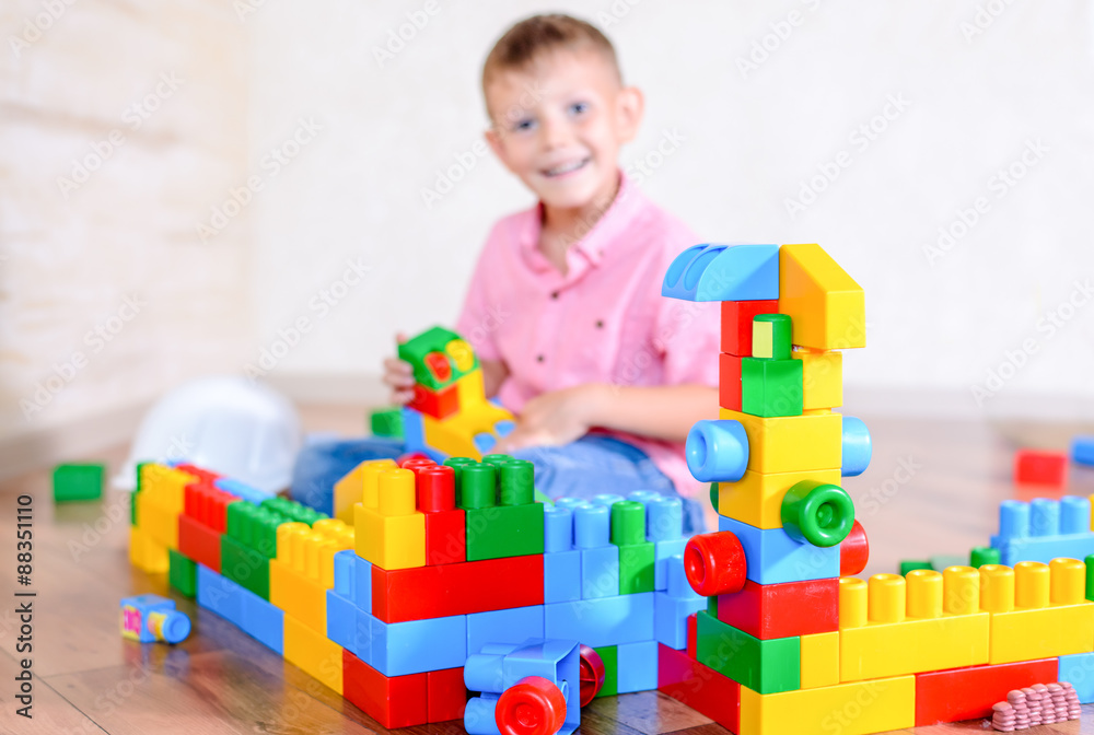Cute cheeky young boy playing with building blocks Cute cheeky young boy playing with building blocks