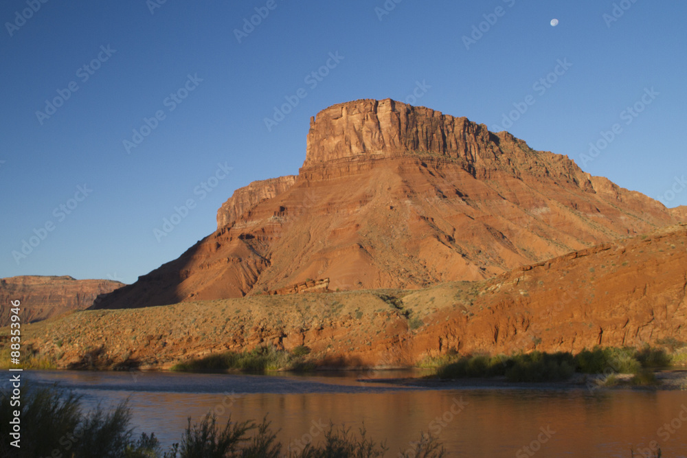 Red sandstone rock formations line the Colorado River.Colorado River Recreation Area.near Moab,Utah