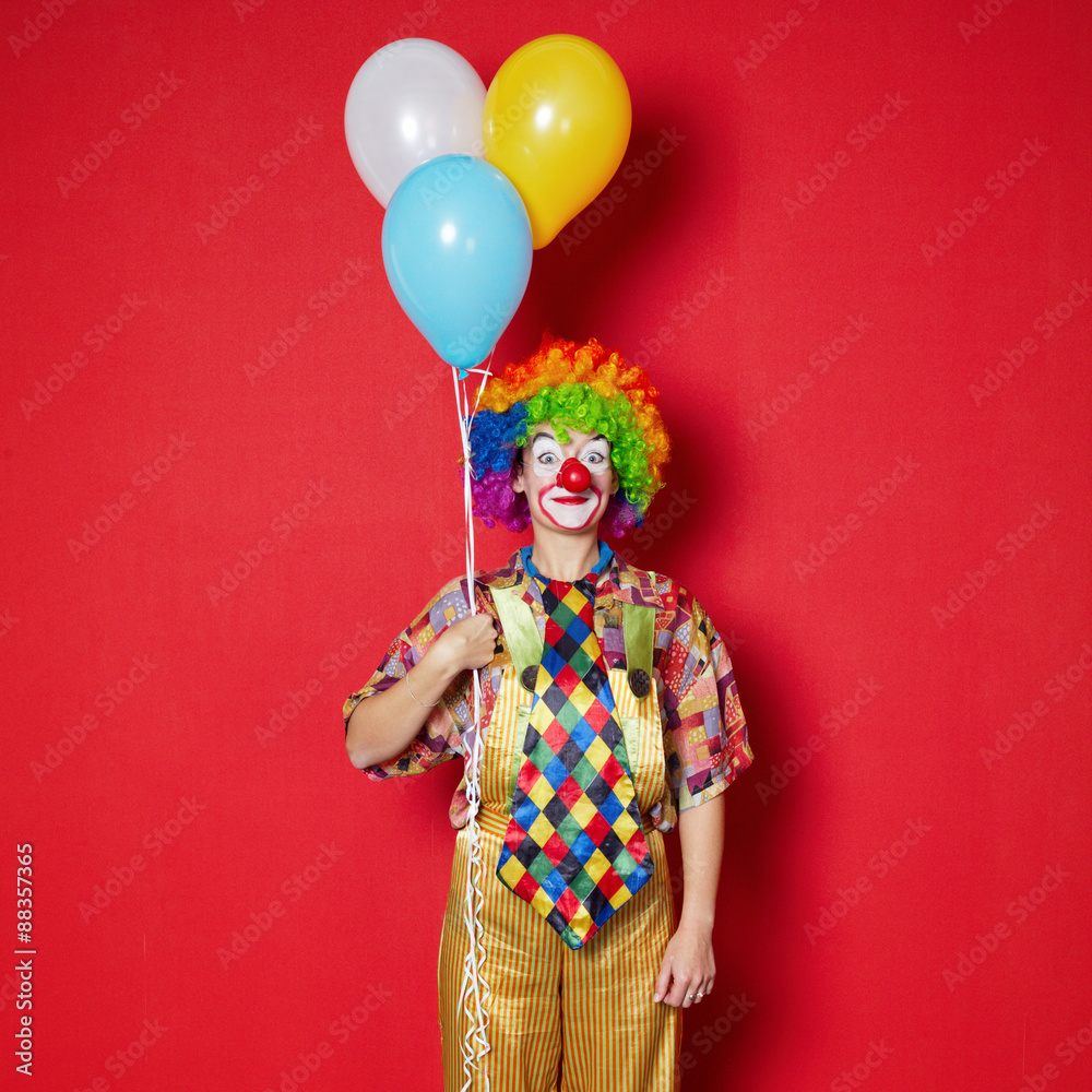 clown with balloons on red background