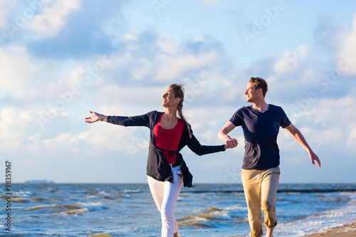 Paar genießt romantischen Sonnenuntergang am Nordsee Strand 