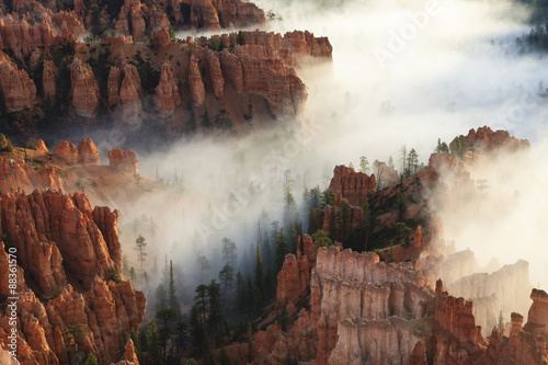 Pinnacles and hoodoos with fog extending into clouds of a partial temperature inversion, Bryce Canyon National Park, Utah #88361570