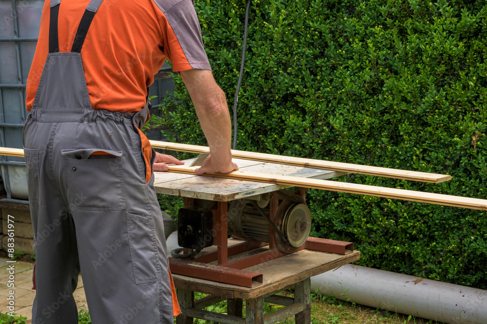 Carpenter working with electric buzz saw cutting wooden boards Carpenter working with electric buzz saw cutting wooden boards