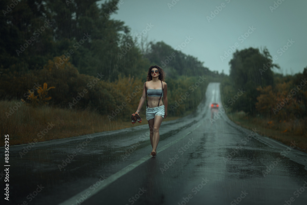Girl walks barefoot on the roadway.