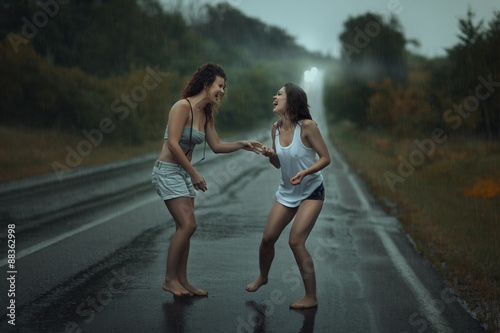 Εκτύπωση καμβά Girls standing in the rain on roadway.