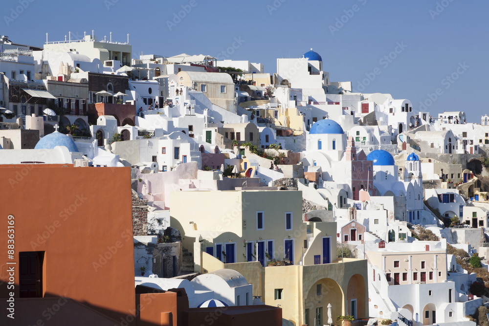 Coloured houses and church with blue dome in the evening light, Oia, Santorini, Cyclades, Aegean Sea, Greek Islands, Greece Coloured houses and church with blue dome in the evening light, Oia, Santorini, Cyclades, Aegean Sea, Greek Islands, Greece