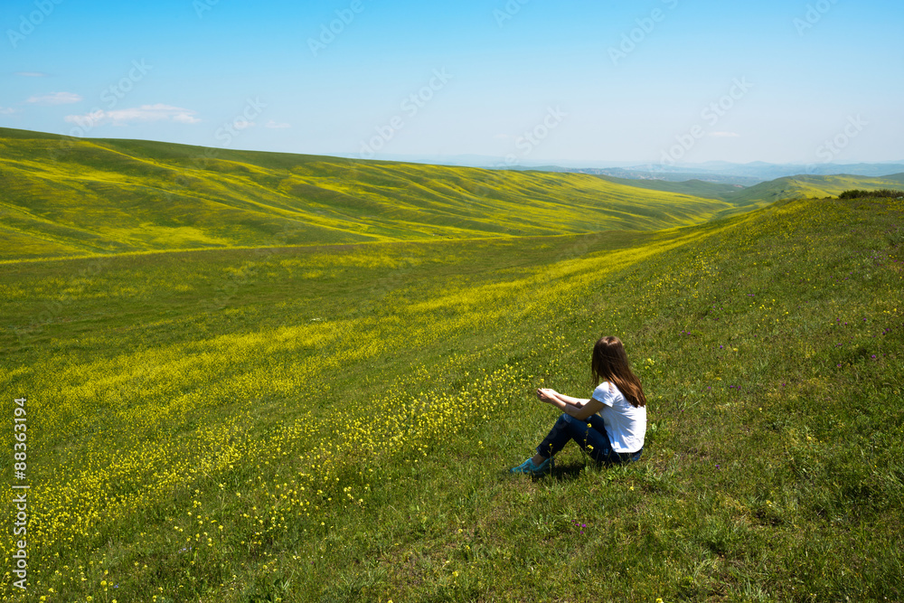 woman sitting and looking at landscape of hills woman sitting and looking at landscape of hills