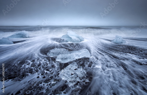 Jokulsa Beach on a stormy day, where icebergs from nearby Jokulsarlon glacial lagoon flow into the North Atlantic and are washed back onto the black volcanic sand beach, on the edge of the Vatnajokull National Park, South Iceland, Iceland