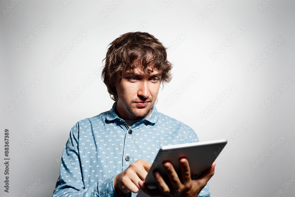 Closeup portrait shouts cheerful young man working on tablet Closeup portrait shouts cheerful young man working on tablet
