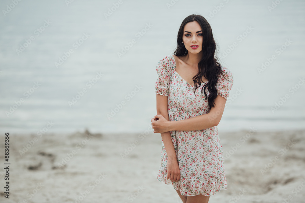 Beautiful and curly girl posing on a background of water Beautiful and curly girl posing on a background of water