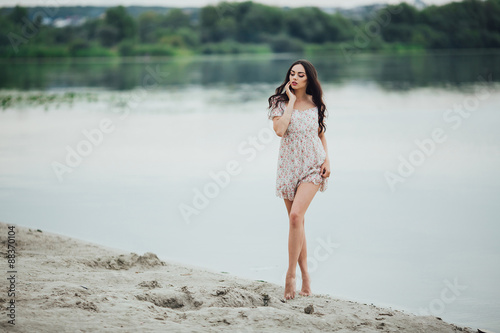 Beautiful and curly girl posing on a background of water