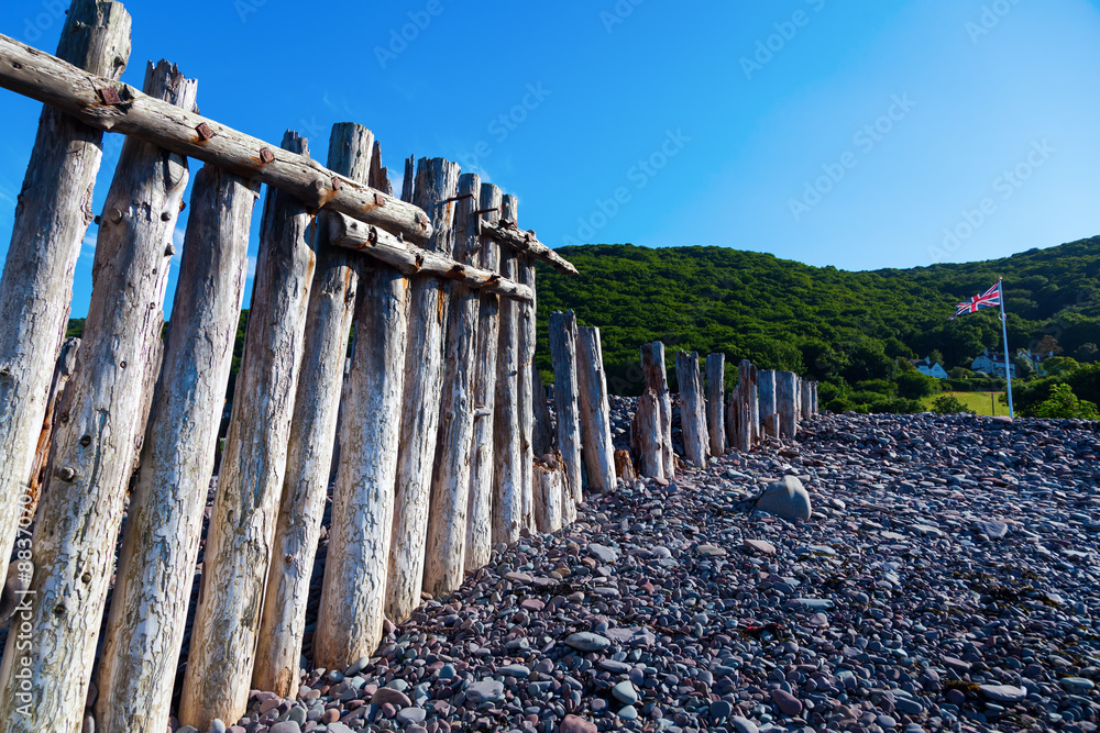 Fototapeta premium Holzpfähle einer Buhne in Porlock Weir, Somerset, England