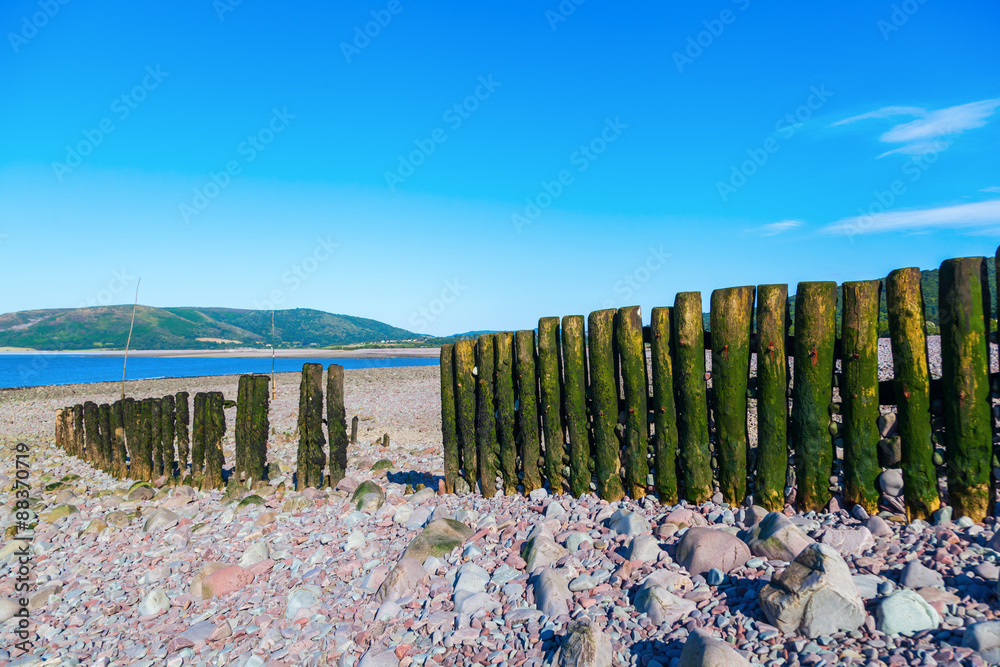 Fototapeta premium Holzpfähle einer Buhne in Porlock Weir, Somerset, England