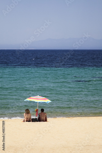 Couple under a parasol at the beach of Porto Puddu, Sardinia, Mediterranean  photo